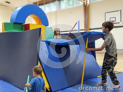 Children making a fort base out of soft play equipment Stock Photo