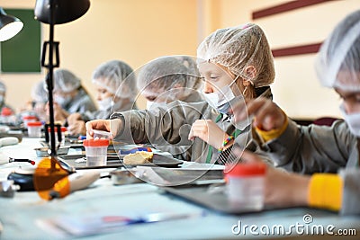 Children in medical uniforms and masks. Training class in dentistry. children and a dentist. Teaching Dentistry Editorial Stock Photo