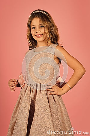 Children model. Little girl in pink dress is posing in a beautiful studio. Stock Photo