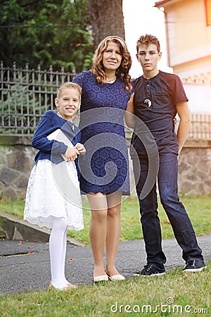 Children with mother are walking under a little rain without umbrellas in the summer Stock Photo