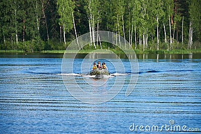 Children in motor boat swim on lake Stock Photo