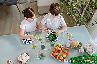 Children painting colorful eggs for easter holidays at home Stock Photo