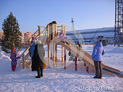Children and parents ride in winter with a wooden slide Editorial Stock Photo
