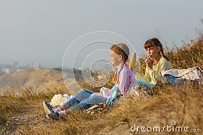 Children on a picnic drink water and eat sweets Stock Photo