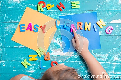 Children play plastic letters to combinations word `Easy Learning` Stock Photo