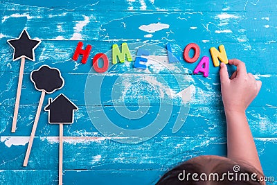 Children play plastic letters to combinations word Home Loan . Stock Photo