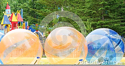 Children play in the pool inside large balls. Favourite children`s water activities - zorbing in the swimming pool. Aquazorbing Stock Photo