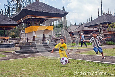 Children play soccer near the Temple Ulun Danau in Bali Editorial Stock Photo