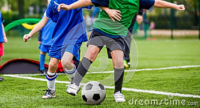 Children play sports. Kids kicking football match. Young boys playing soccer on the green grass pitch. Youth sports competiton. Stock Photo