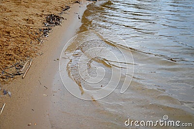 Children play with it and step on it with shoes holding it in their hands. white hands from foam shoes in the water on the shore a Stock Photo