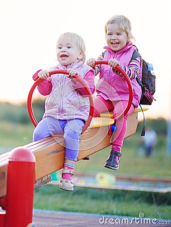 Children play teeter-totter outdoor Stock Photo