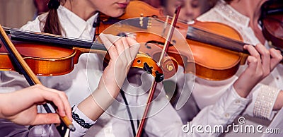 Children play violins during the concert. Performing Classical Music on Violins_ Editorial Stock Photo