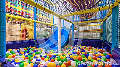Children playground indoor. Nice plastic gym for activity in playroom. Panorama inside the plastic dry pool with colorful balls Stock Photo