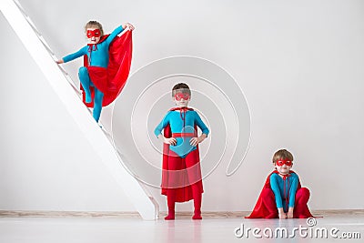 Children playing as superheroes with red coats Stock Photo