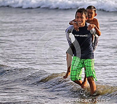 CHILDREN PLAYING AT THE BEACH IN INDONESIA Editorial Stock Photo