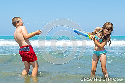 Children playing on the beach waterfighting Stock Photo