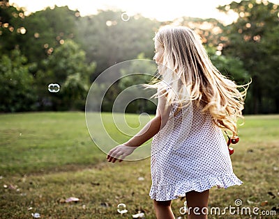 Children is playing bubbles in a park Stock Photo