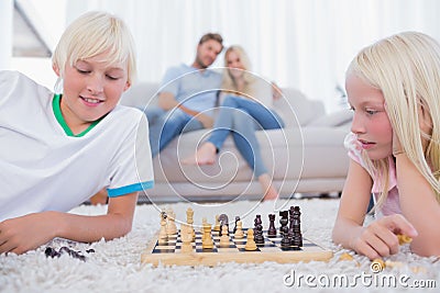 Children playing chess in the living room Stock Photo