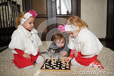 Children playing chess lying on floor Stock Photo