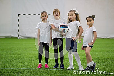 Children playing football indoors. Football team contains four girls Stock Photo