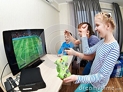 Children playing on games console to play football Stock Photo