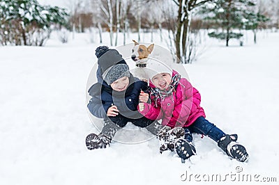 Children playing with Jack Russell terrier puppy in the park in the winter in the snow Stock Photo