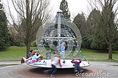 Children playing merry go round Editorial Stock Photo