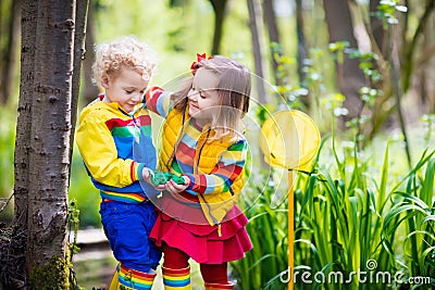 Children playing outdoors catching frog Stock Photo