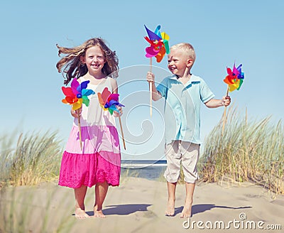 Children Playing Pinwheels by the Coastline Stock Photo