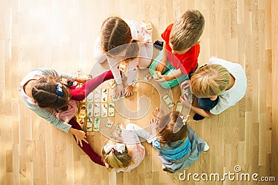Children playing with puzzle cards for child development in play room. Card with animals mom and baby. Stock Photo