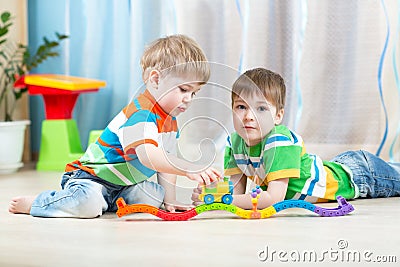 Children playing rail road toy in nursery Stock Photo