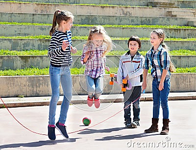 Children playing skipping rope jumping game Stock Photo