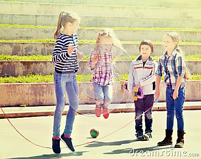 Children playing skipping rope jumping game Stock Photo