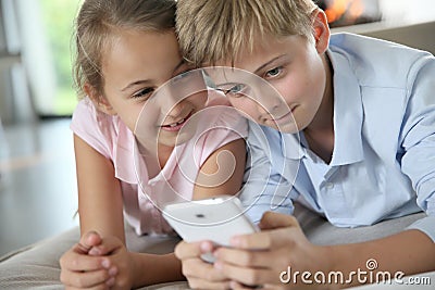 Children playing together on smartphone Stock Photo