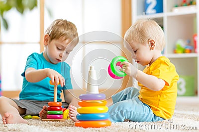 Children playing together. Toddler kid and baby play with blocks. Educational toys for preschool kindergarten child Stock Photo