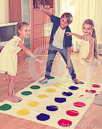 Children playing twister at home Stock Photo