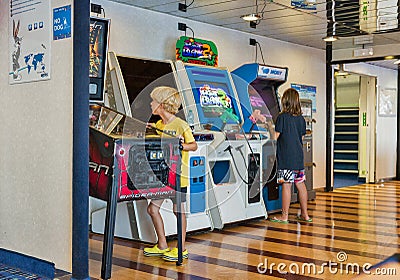 Children plays fighting game on arcade machine. Moby ferry ship Editorial Stock Photo