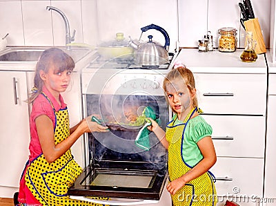 Children poorly cooking chicken at kitchen. Stock Photo