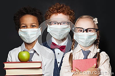 Children in protective face mask on black background, back to school and covid-19 concept Stock Photo