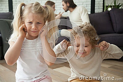 Children put fingers in ears during parents fighting at home Stock Photo