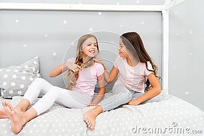 Children relax and having fun in evening. Sisters leisure. Girls in cute pajamas spend time together in bedroom. Sisters Stock Photo