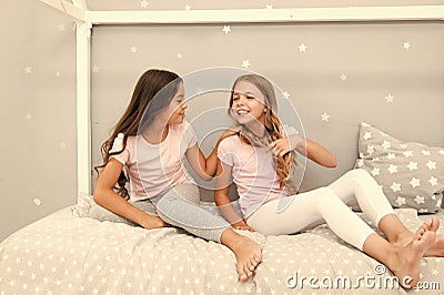 Children relax and having fun in evening. Sisters leisure. Girls in cute pajamas spend time together in bedroom. Sisters Stock Photo