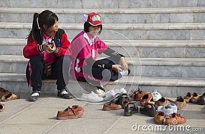 Children removing their shoes before entering building Editorial Stock Photo