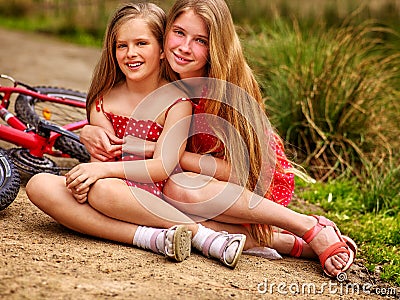 Children rides bicycle and have rest on country park road . Stock Photo