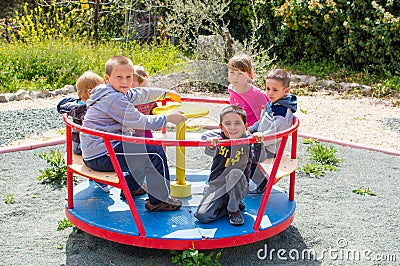 Children riding roundabout Stock Photo