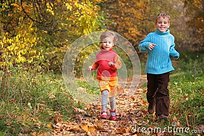 Children run on wood autumn footpath Stock Photo