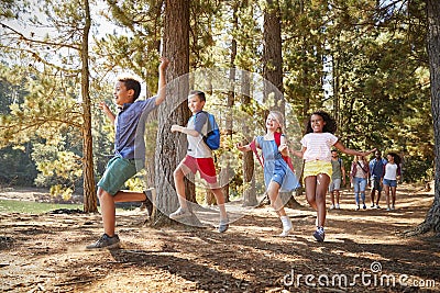 Children Running Ahead Of Parents On Family Hiking Adventure Stock Photo