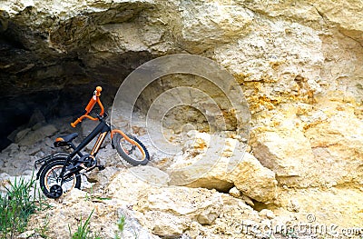 Children`s bicycle on the background of rocks and stones Stock Photo