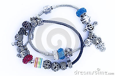 Children`s bracelet with jewelry. A bijouterie set consisting of a necklace and hanging silver earrings with a blue stone. Stock Photo