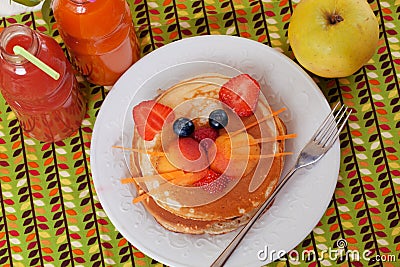 Children's breakfast pancakes smiling face of the cat, kitten, strawberry blueberry and apricot, cute food, honey Stock Photo